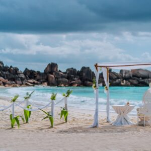 Beach wedding arch ceremonial decorated with white flowers on a tropical white sand beach. Paradise