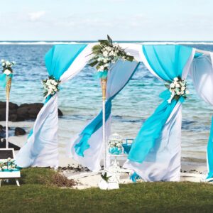Beautiful white wedding arch for the ceremony on the ocean.