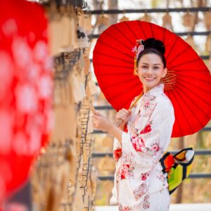 Portrait close up of pretty young woman wear japanese style dress and hold red umbrella