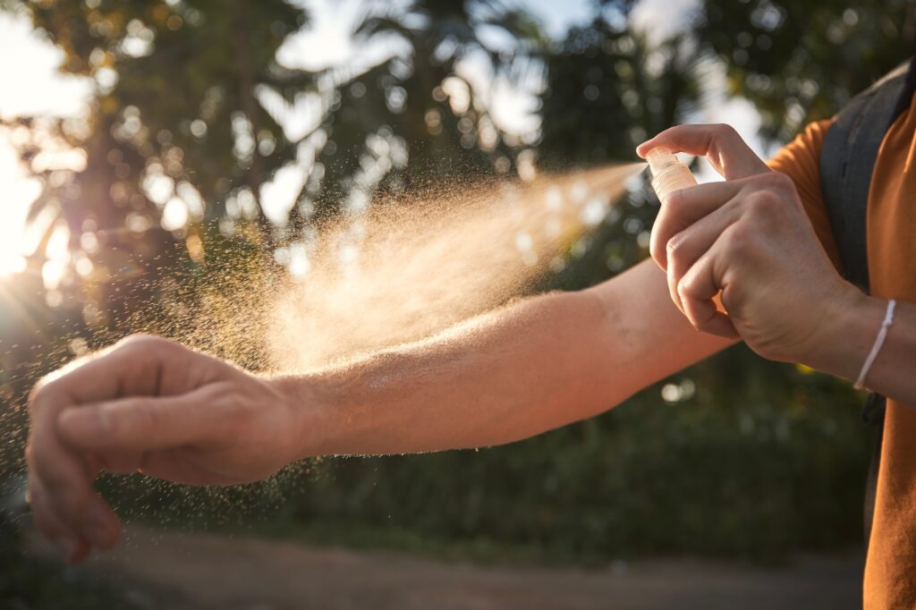 Man is applying insect repellent on his hand